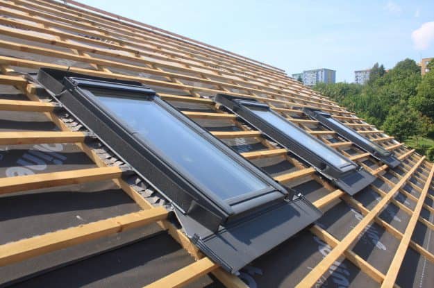Pose de Velux sur un toit avec une pose intégrale d’une toiture en tuile à Sète sur une maison en construction par JTC couverture.